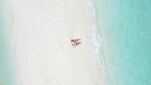 Pareja disfrutando de un momento romántico en una playa paradisíaca de Maldivas, rodeados de aguas turquesas, arena blanca y un paisaje tropical único