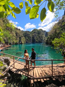 Pareja explorando el paraíso de Coron, Filipinas, rodeada de aguas cristalinas, montañas de karst y un paisaje natural espectacular en este destino tropical único