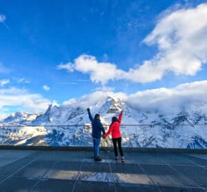 Pareja-de-viajeros-en-los-Alpes-Suizos-disfrutando-de-un-paisaje-montañoso-impresionante-entre-nieve-y-naturaleza-una-aventura-inolvidable-de-Viajeros-por-el-Mundo