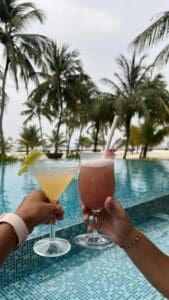 Cócteles coloridos y refrescantes servidos junto a la piscina, con un fondo relajante de agua cristalina y un ambiente veraniego perfecto para disfrutar