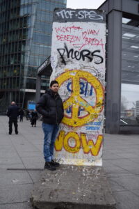 hombre-parado-sobre-muro-berlin-restos-historicos-monumento-memoria