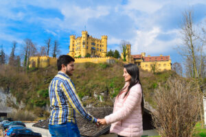 pareja-de-viajeros-posando-frente-al-castillo-hohenschwangau-en-baviera-alemania